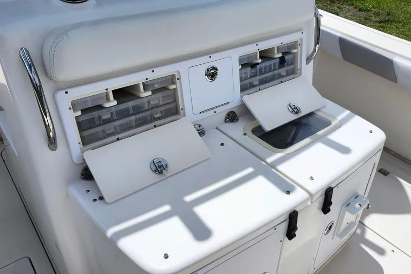 Slide: The Image of 2015 Robalo R300 Center Console boat with storage compartments and tackle boxes. - 9