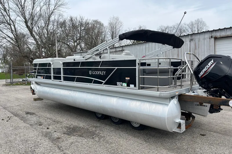 Slide: The Image of 2023 Godfrey Sweetwater 2286 pontoon boat with Mercury engine, parked outdoors. - 5