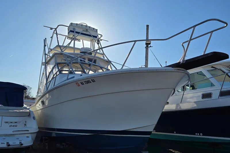 The Image of 1987 Topaz 29 Sportfisherman boat docked under clear blue sky. - 0