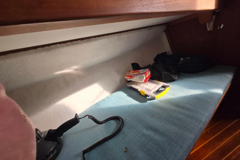 Slide: The Image of Interior of 1987 Topaz 29 Sportfisherman with storage items on a cushioned bench. - 12