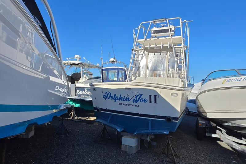 Slide: The Image of 1987 Topaz 29 Sportfisherman boat "Dolphin Joe II" in storage, surrounded by other boats. - 13