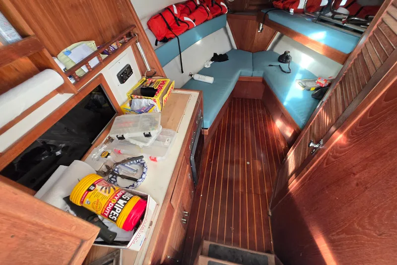 Slide: The Image of Interior of 1987 Topaz 29 Sportfisherman boat with wooden flooring and storage. - 2