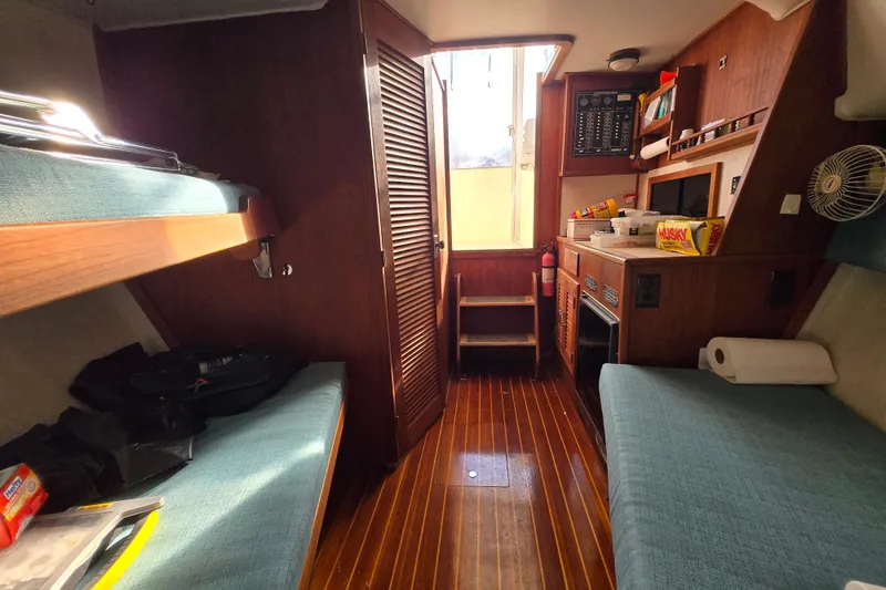Slide: The Image of Interior of a 1987 Topaz 29 Sportfisherman boat with wooden flooring and cozy seating. - 3