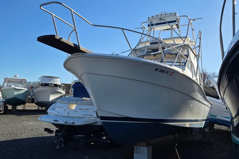 Slide: The Image of 1987 Topaz 29 Sportfisherman boat in storage, surrounded by other vessels. - 6