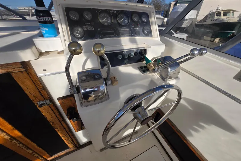 Slide: The Image of 1987 Topaz 29 Sportfisherman helm with steering wheel, throttle controls, and instrument panel. - 8