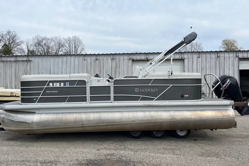 Slide: The Image of 2022 Godfrey Sweetwater 2286 SBX pontoon boat parked outdoors, side view. - 2