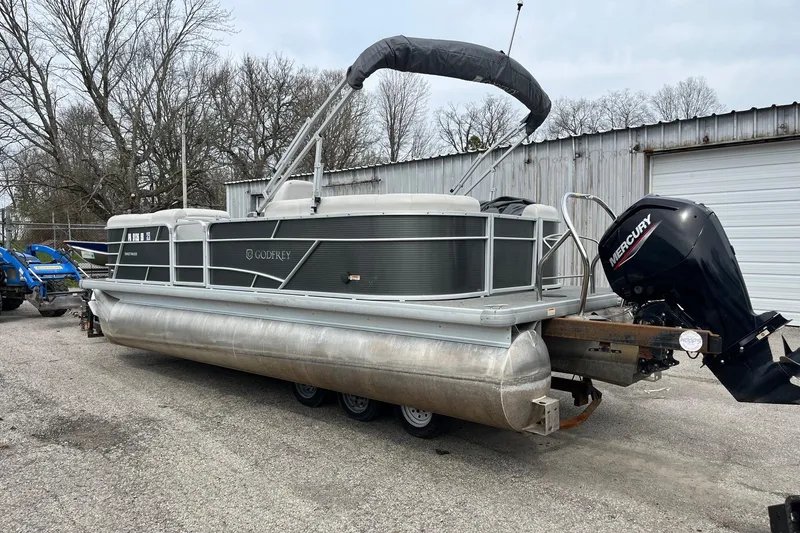 Slide: The Image of 2022 Godfrey Sweetwater 2286 SBX pontoon boat with Mercury outboard motor in a yard. - 3