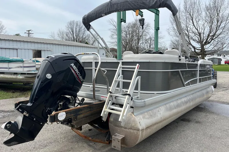 Slide: The Image of 2022 Godfrey Sweetwater 2286 SBX pontoon boat with Mercury outboard motor, parked outdoors. - 4