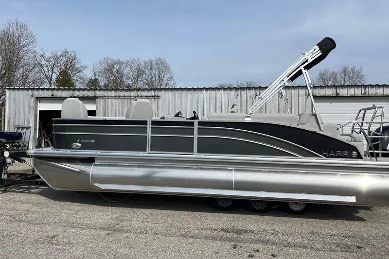 The Image of 2026 Harris Cruiser 230 SL pontoon boat parked outside a metal building. - 0