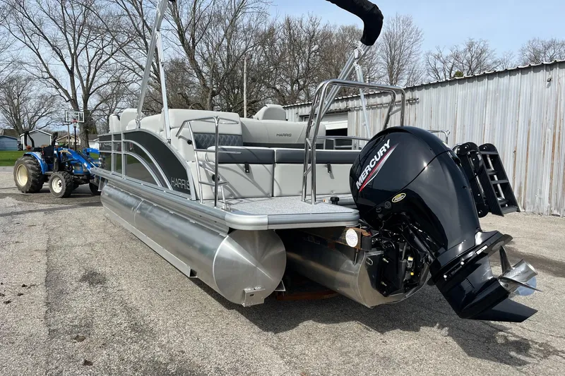 Slide: The Image of 2026 Harris Cruiser 230 SL pontoon boat with Mercury outboard motor, parked outdoors. - 3