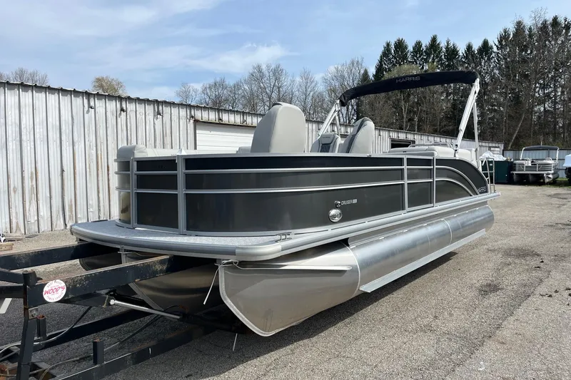 Slide: The Image of 2026 Harris Cruiser 230 SL pontoon boat on trailer, parked outdoors. - 4