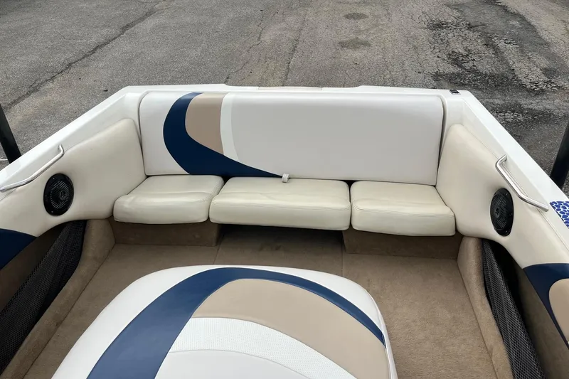 Slide: The Image of 2001 Malibu Sunsetter boat interior with white and blue seating, featuring built-in speakers. - 12