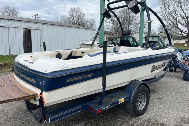 Slide: The Image of 2001 Malibu Sunsetter boat on trailer, parked outdoors, featuring a wakeboard tower. - 3