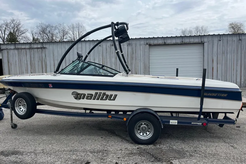 Slide: The Image of 2001 Malibu Sunsetter boat on trailer, parked outside a metal building. - 6
