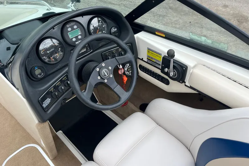 Slide: The Image of 2001 Malibu Sunsetter boat dashboard with steering wheel and control panel. - 8