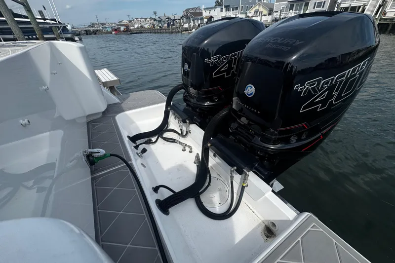 Slide: The Image of 2015 Belzona 32 CC boat with dual Mercury Racing 400 outboard engines docked by waterfront homes. - 11