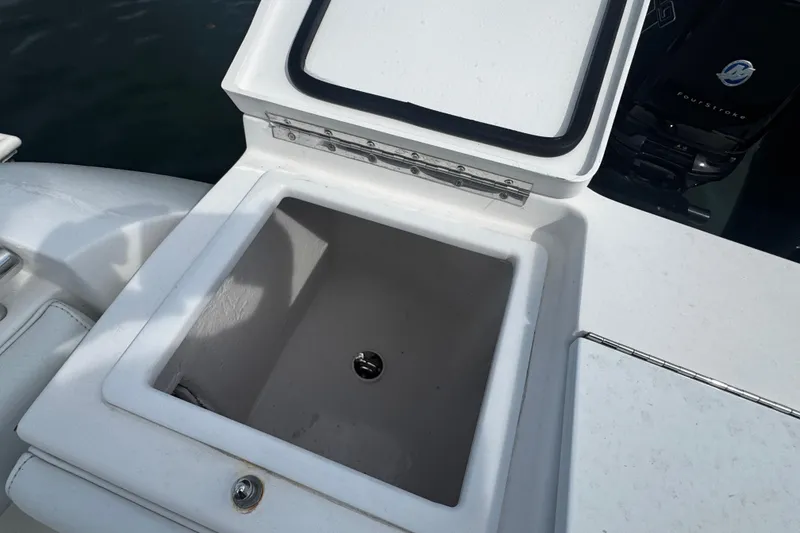 Slide: The Image of Open storage compartment on a 2015 Belzona 32 CC boat, with visible engine in background. - 14