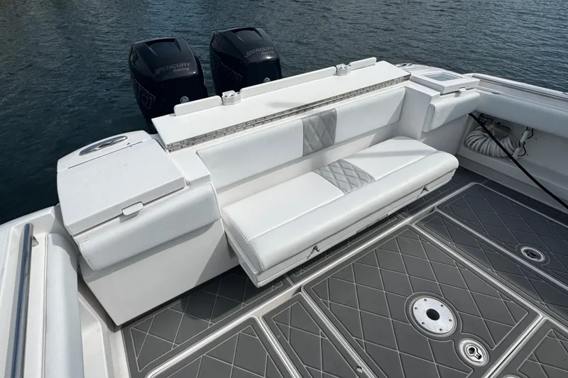 Slide: The Image of 2015 Belzona 32 CC boat with white seating and dual Mercury engines on water. - 15