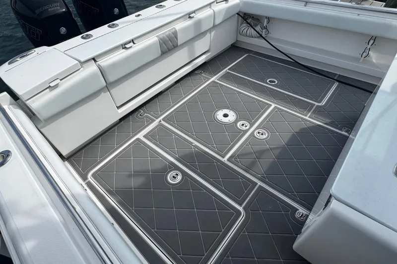 Slide: The Image of 2015 Belzona 32 CC boat deck with cushioned seating and sleek gray flooring. - 18