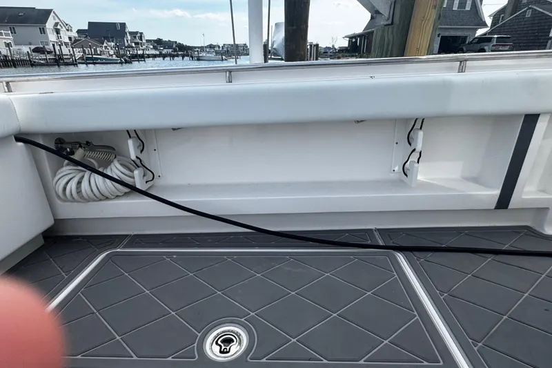 Slide: The Image of 2015 Belzona 32 CC boat deck with storage compartment and coiled hose. - 19