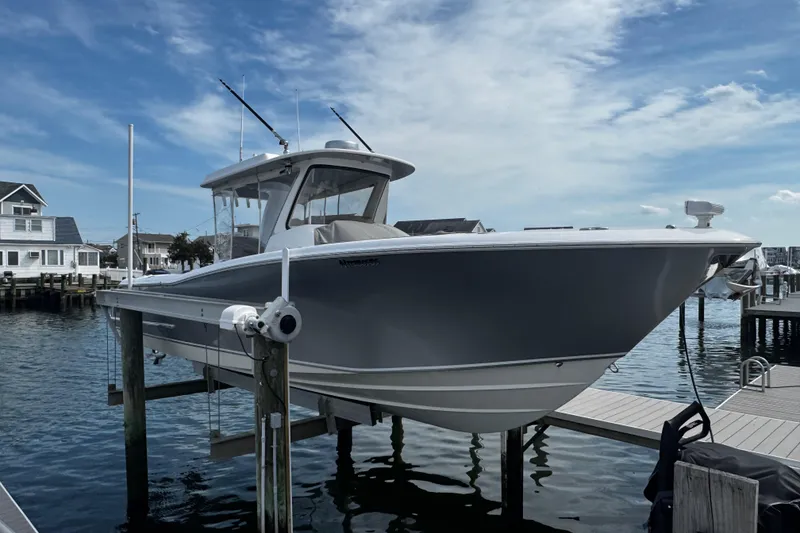 Slide: The Image of 2015 Belzona 32 CC boat docked at marina under clear blue sky. - 2