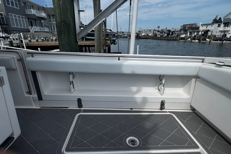 Slide: The Image of 2015 Belzona 32 CC boat interior with dockside view, featuring sleek seating and flooring. - 20