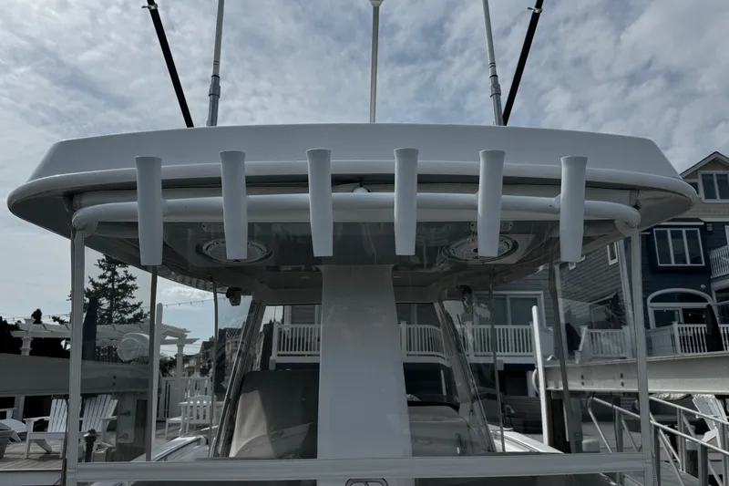 Slide: The Image of 2015 Belzona 32 CC boat with rod holders, docked near waterfront homes. - 29