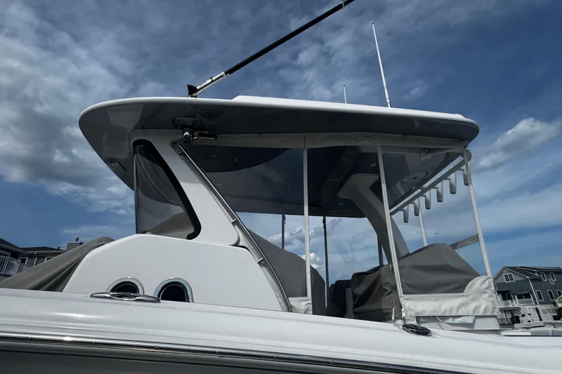 Slide: The Image of 2015 Belzona 32 CC boat with covered seating, under a clear blue sky. - 3