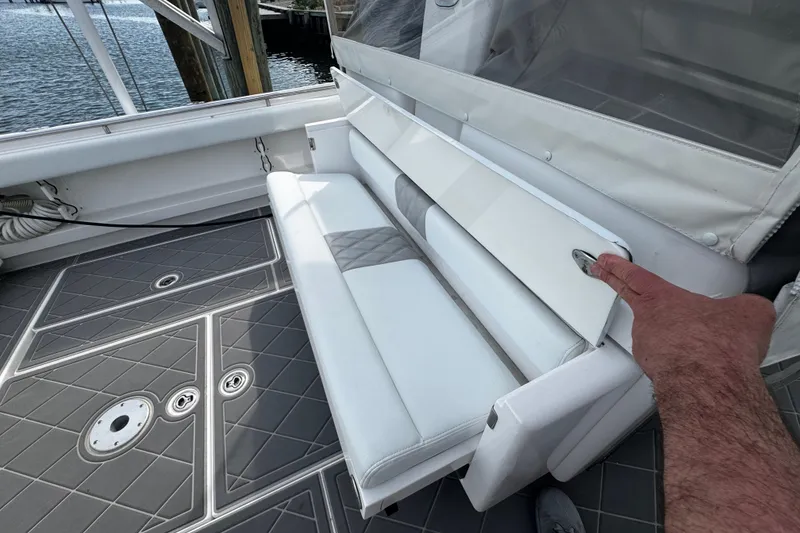 Slide: The Image of 2015 Belzona 32 CC boat with white seating and gray deck, docked by water. - 32