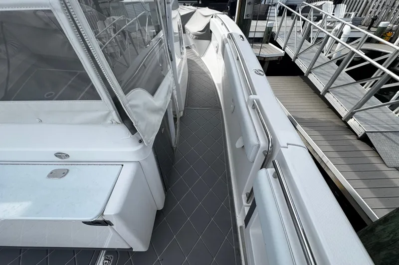 Slide: The Image of 2015 Belzona 32 CC boat deck with sleek design and modern features at a marina. - 33