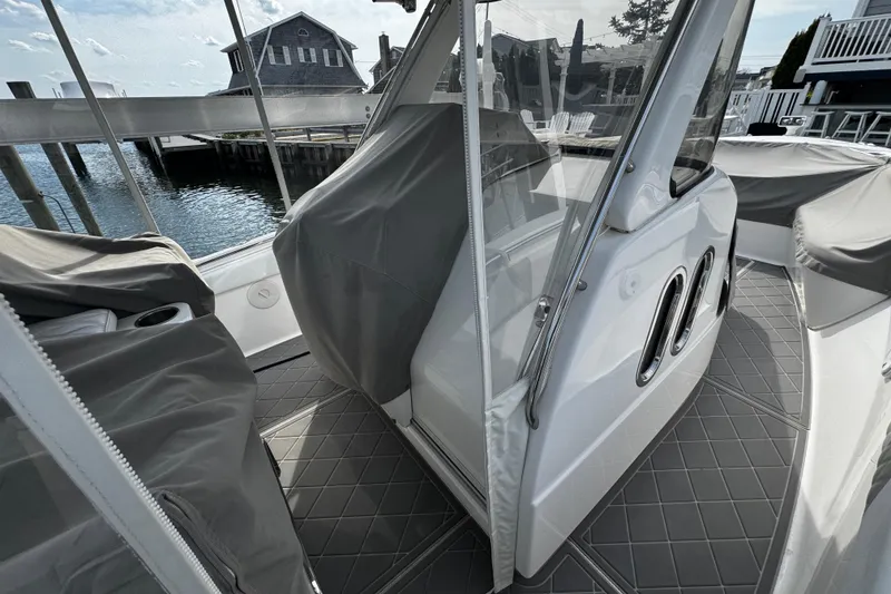 Slide: The Image of 2015 Belzona 32 CC boat interior with protective covers, docked by the water. - 36