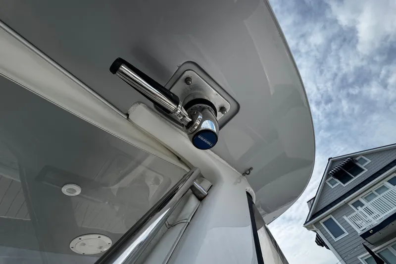 Slide: The Image of Close-up of a 2015 Belzona 32 CC boat detail with a house in the background. - 38