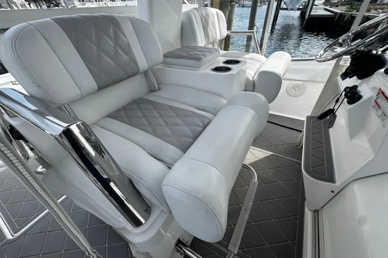 Slide: The Image of Luxurious seating on a 2015 Belzona 32 CC boat, featuring diamond-stitched upholstery and cup holders. - 43