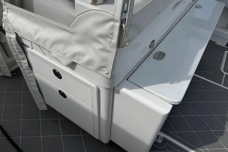 Slide: The Image of Interior view of a 2015 Belzona 32 CC boat, featuring storage compartments and seating. - 44