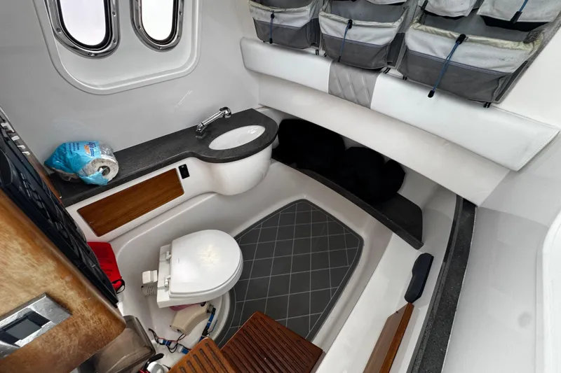 Slide: The Image of Interior of a 2015 Belzona 32 CC boat featuring a compact bathroom with sink and toilet. - 48
