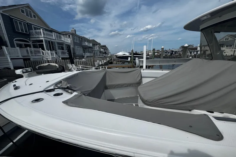 Slide: The Image of 2015 Belzona 32 CC boat docked near waterfront homes under a cloudy sky. - 5
