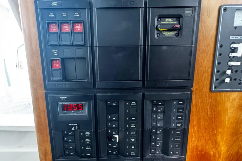 Slide: The Image of Electrical control panel on a 2015 Belzona 32 CC boat, featuring circuit breakers and switches. - 51