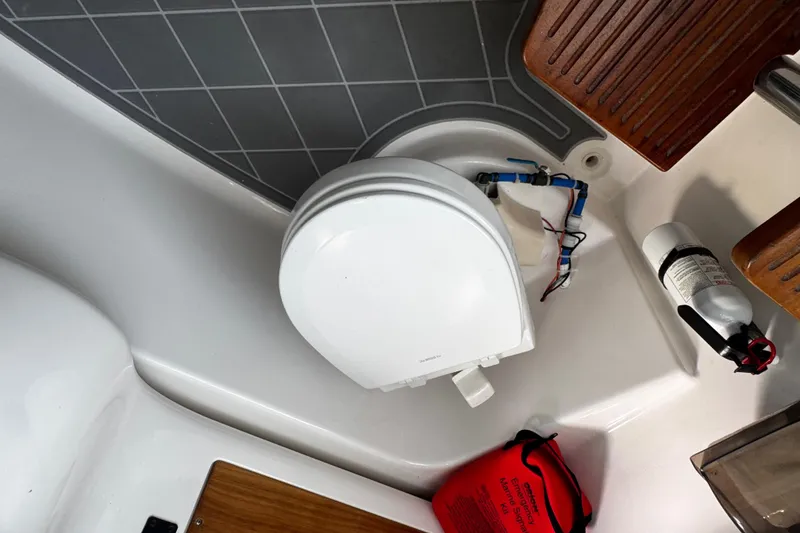 Slide: The Image of Boat bathroom with toilet, fire extinguisher, and emergency kit on a 2015 Belzona 32 CC. - 52