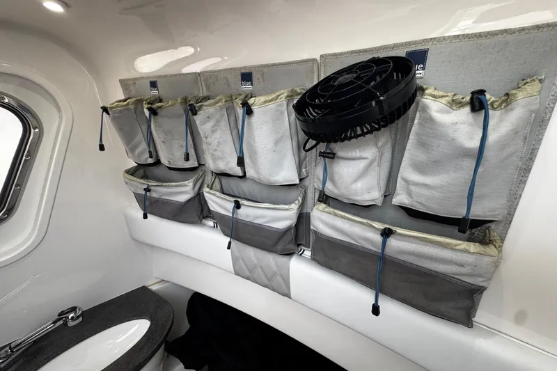 Slide: The Image of Interior of a 2015 Belzona 32 CC boat with organized storage pouches and a fan. - 54