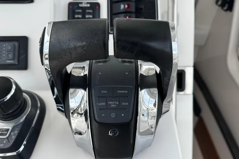 Slide: The Image of Close-up of throttle controls on a 2015 Belzona 32 CC boat dashboard. - 64