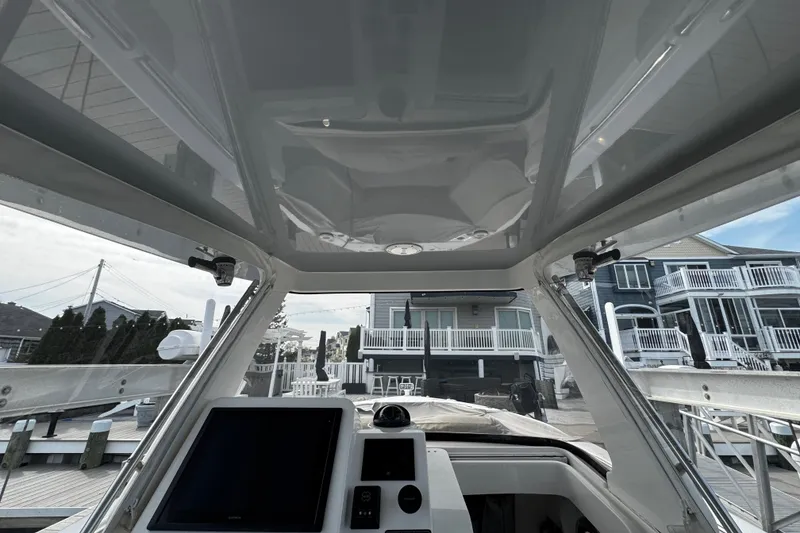 Slide: The Image of Interior view of 2015 Belzona 32 CC boat with modern dashboard and waterfront background. - 67
