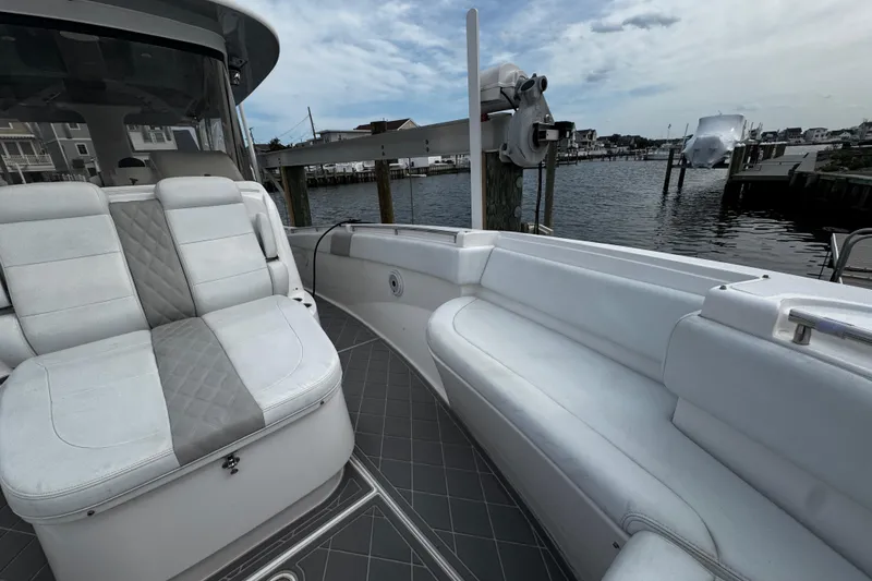 Slide: The Image of 2015 Belzona 32 CC boat interior with white seating, dockside view. - 76