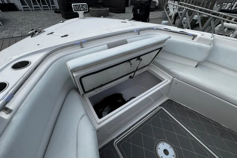 Slide: The Image of 2015 Belzona 32 CC boat interior with open storage compartment and seating area. - 80