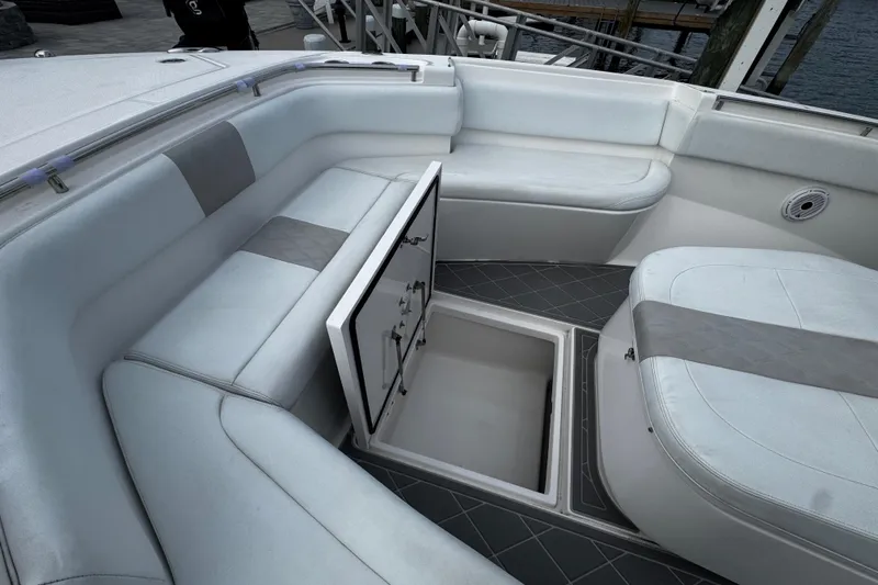 Slide: The Image of 2015 Belzona 32 CC boat interior with open storage compartment and cushioned seating. - 81