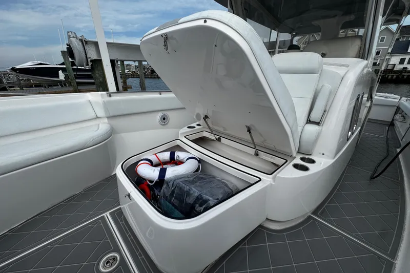 Slide: The Image of 2015 Belzona 32 CC boat with open storage compartment, docked at marina. - 84