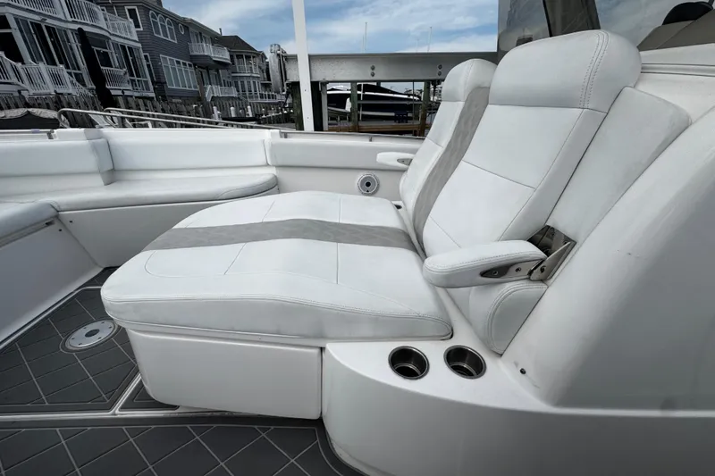 Slide: The Image of Luxurious seating on a 2015 Belzona 32 CC boat, featuring white upholstery and cup holders. - 85