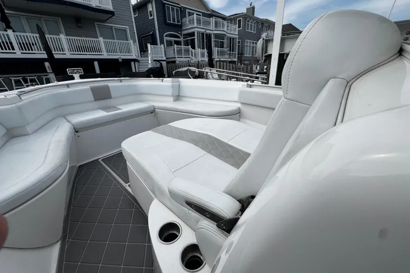 Slide: The Image of Interior view of a 2015 Belzona 32 CC boat with white seating and cup holders. - 86