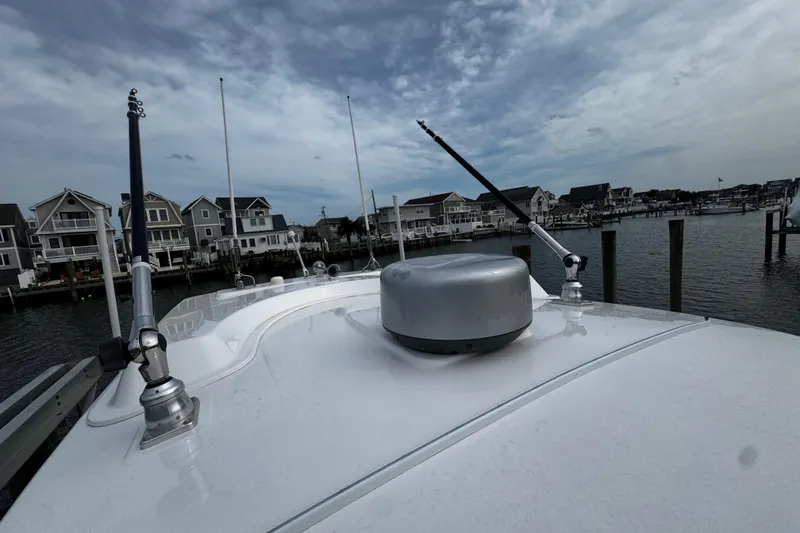 Slide: The Image of 2015 Belzona 32 CC boat docked near waterfront homes under cloudy sky. - 89