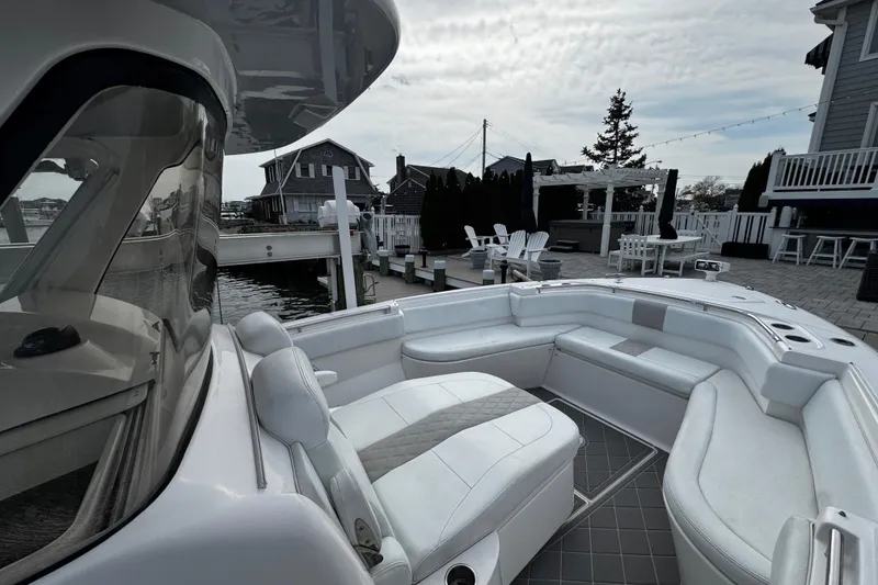 Slide: The Image of 2015 Belzona 32 CC boat with spacious seating, docked near waterfront homes. - 91