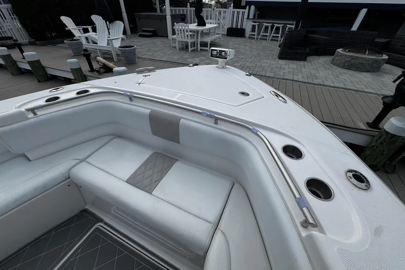 Slide: The Image of 2015 Belzona 32 CC boat interior with white seating and cup holders, dockside view. - 92